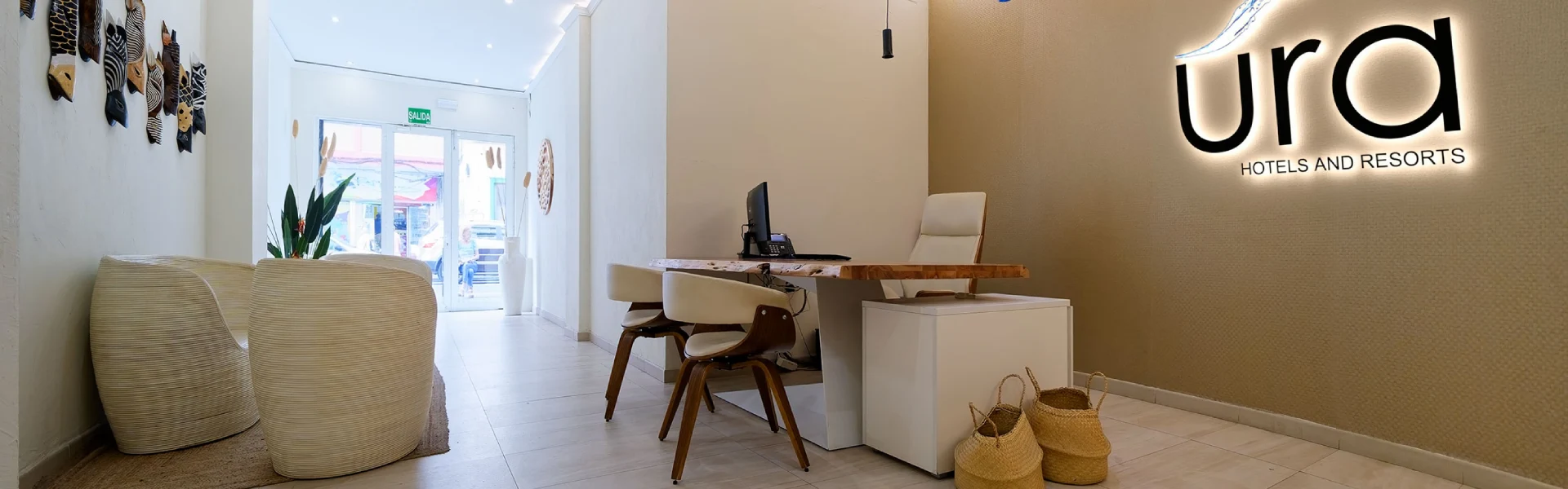 Recepci&oacute;n moderna de hotel con decoraci&oacute;n elegante y escritorio de madera.