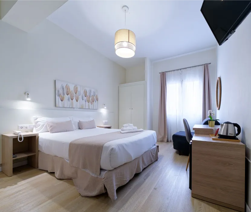 Habitaci&oacute;n de hotel moderna con cama doble y decoraci&oacute;n minimalista.