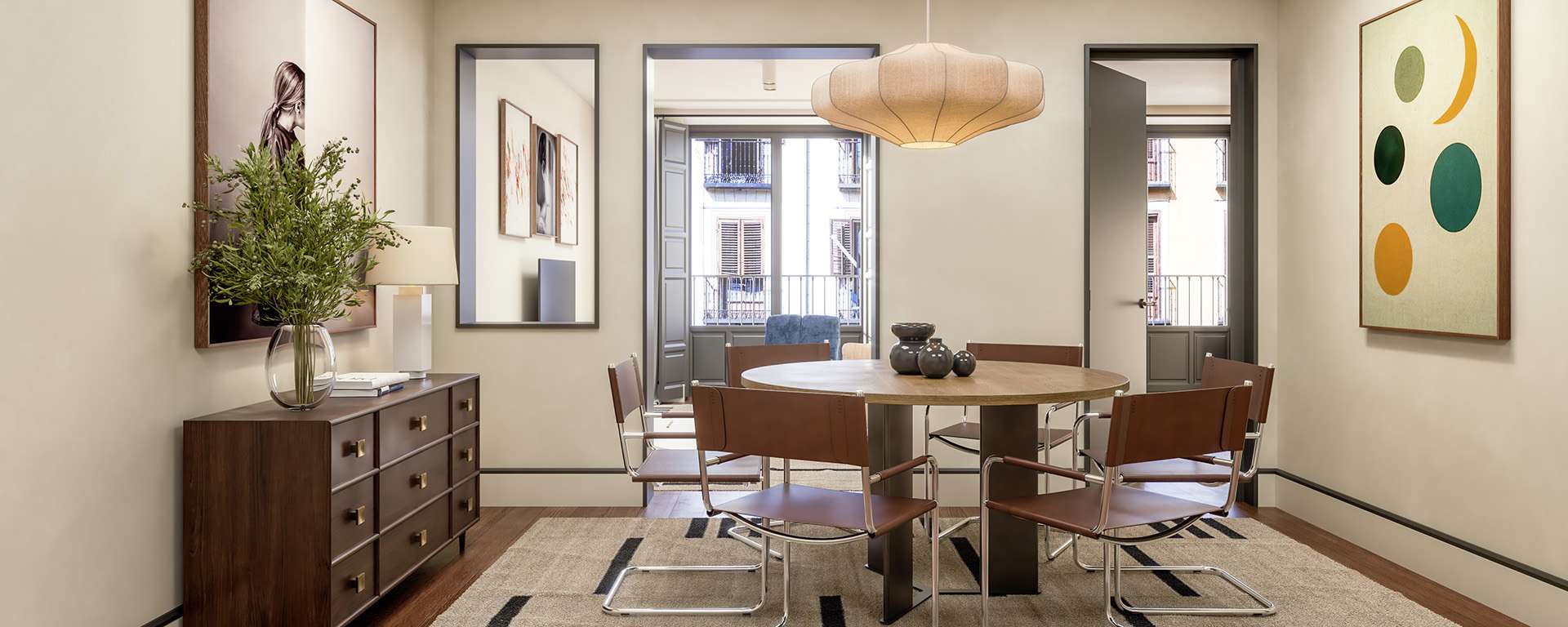 Comedor moderno con mesa redonda, sillas y arte en las paredes.