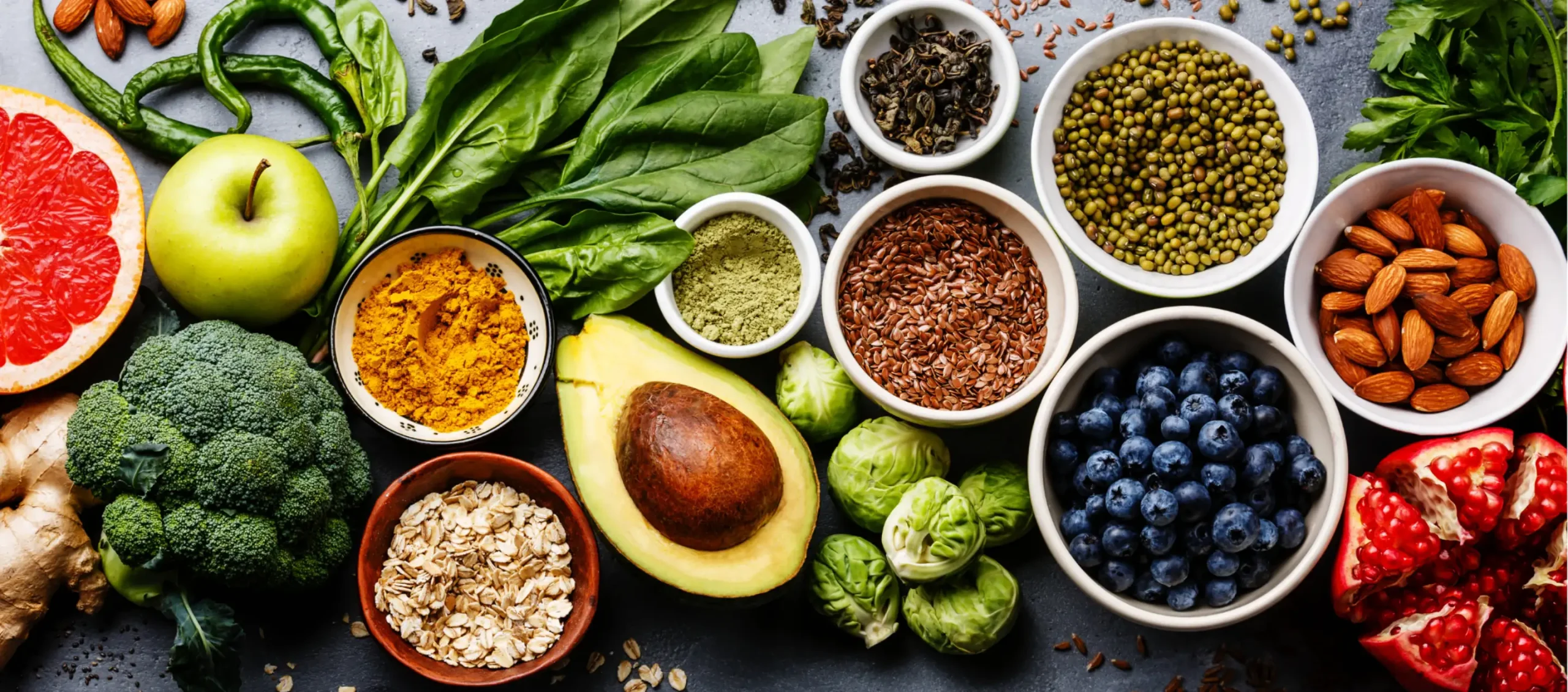 a colorful variety of fresh fruits and vegetables, including broccoli, spinach, blueberries and avocado.