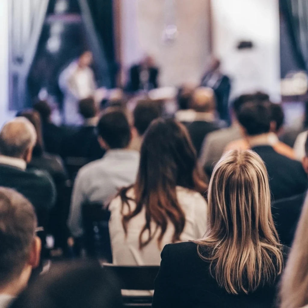 Audience members attentively listening at a conference event