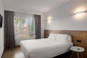 Stylish hotel interior showcasing a comfortable bed and elegant wooden accents.