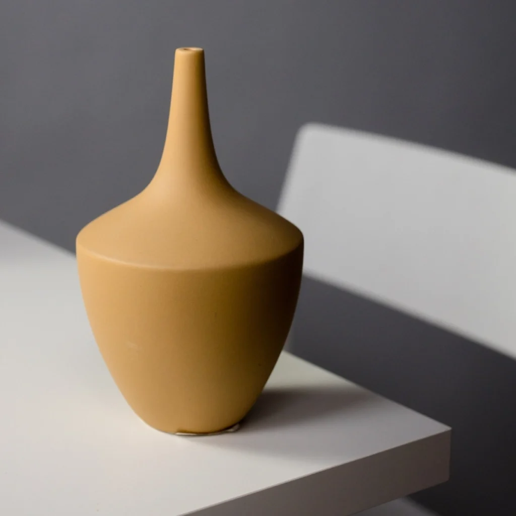 Modern brown vase on a white table.