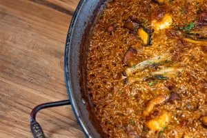 Frying pan with food on a table, showing an appetizing dish ready to be served and enjoyed.