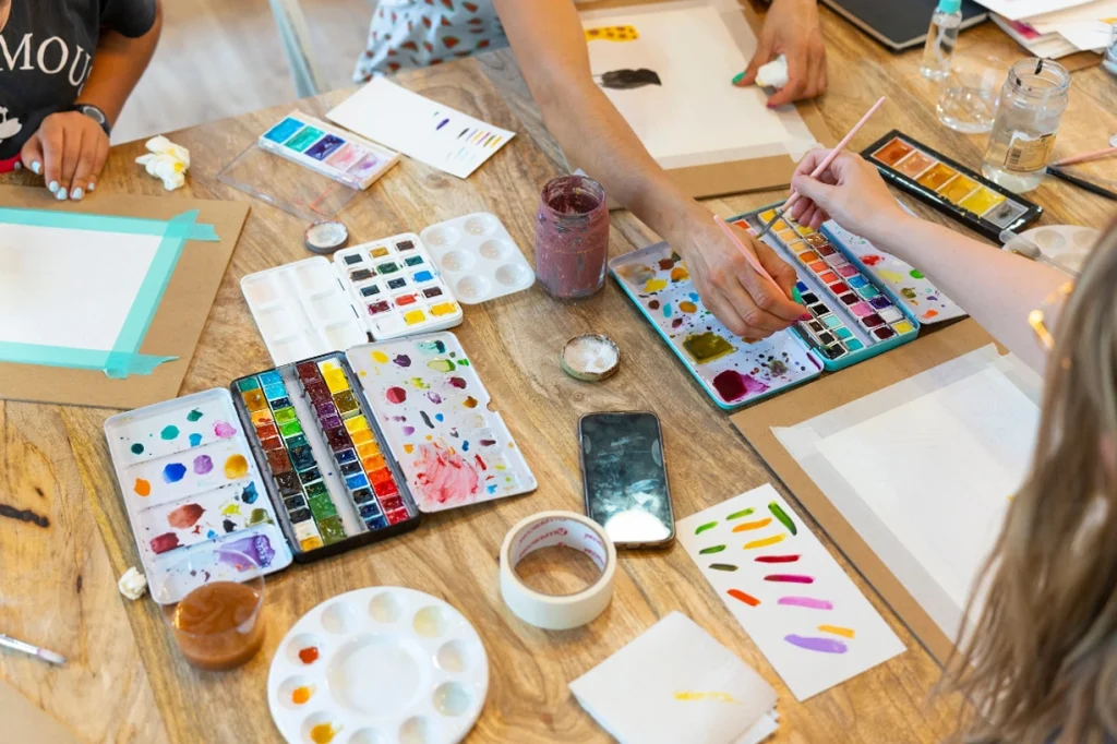 view of a table with watercolors and painting tools