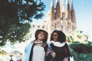 Two friends enjoying a sunny day in Barcelona with the Sagrada Familia in the background.