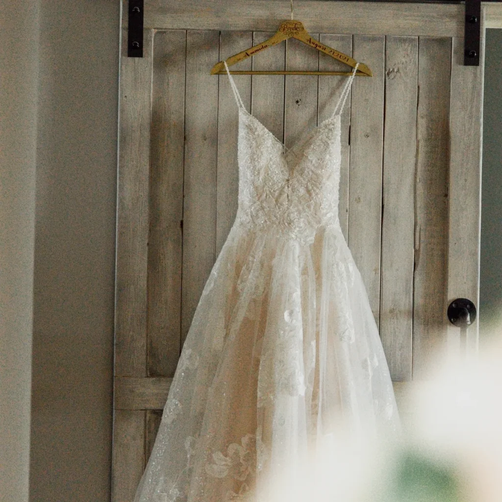 Elegant wedding dress hanging on a rustic wooden door