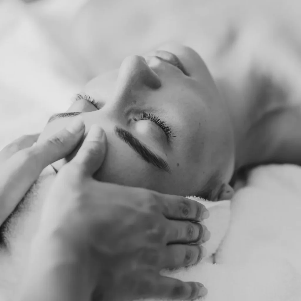 A serene woman receiving a facial massage in a spa setting