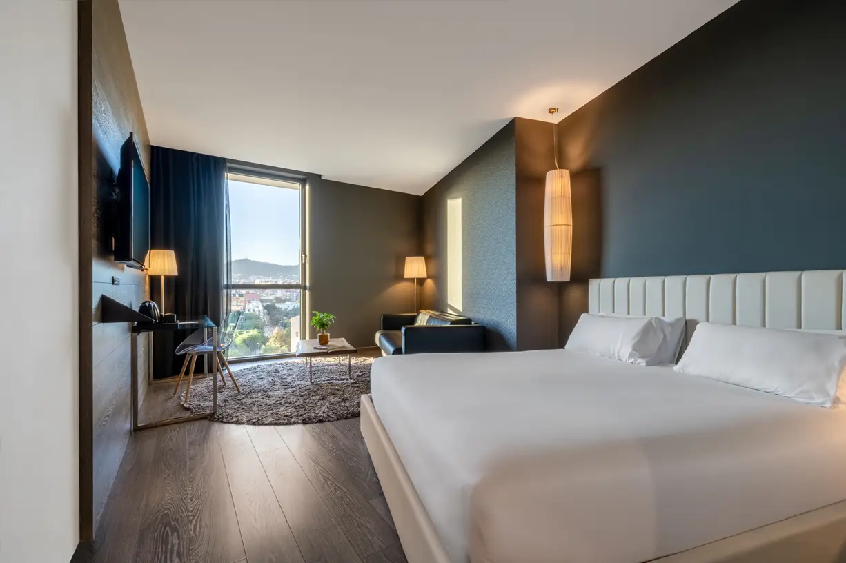 A modern room with a large bed and a city view