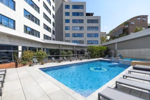 A pool with city buildings in the background