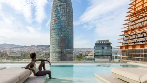 View of the swimming pool and the Agbar Tower on a sunny day in Barcelona.