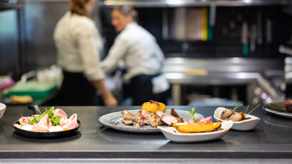 chefs working in a professional kitchen with elaborated dishes