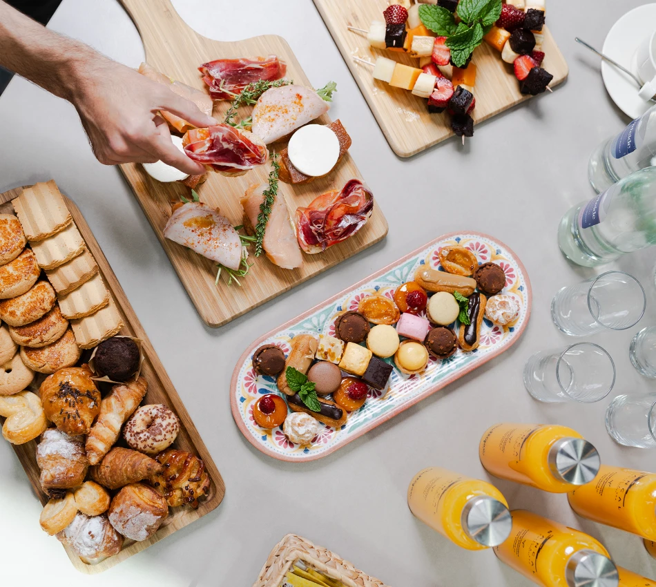 Variedad de entremeses en tablas de madera y mesa, con bebidas y copas.