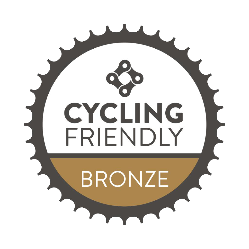 Insignia "Cycling Friendly Bronze" con borde en forma de engranaje.