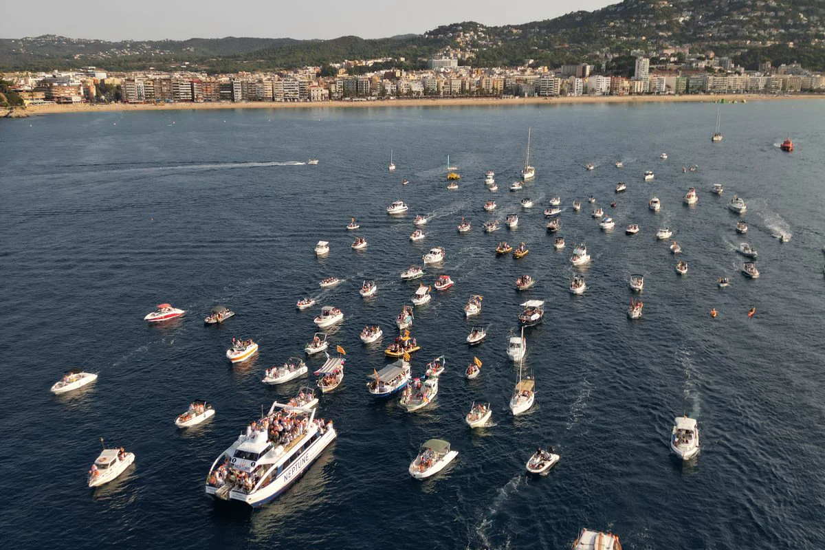 Barcas navegando juntas en la procesión marítima de Santa Cristina en Lloret de Mar