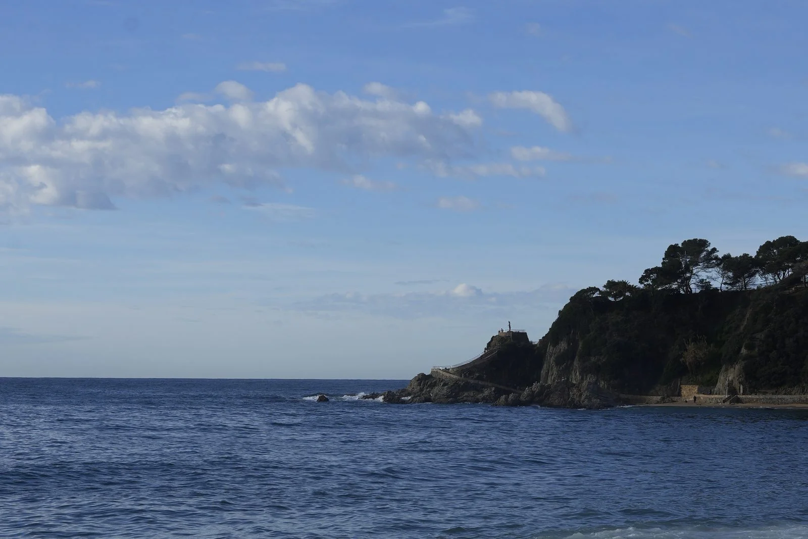 Mar y cabo de Lloret de Mar bajo un cielo con nubes en septiembre