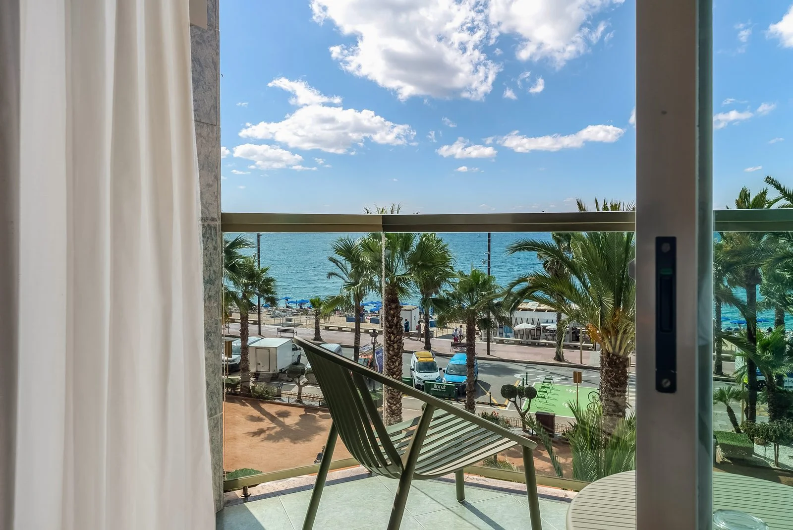 Vista desde la terraza de una habitaci&oacute;n del Hotel Miramar: paseo mar&iacute;timo con palmeras y el mar