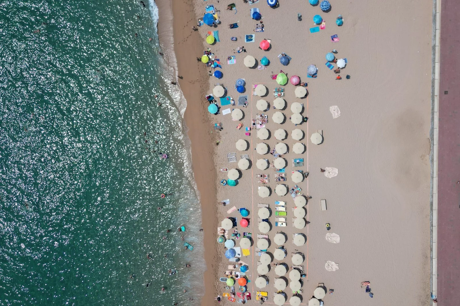 Vista a&eacute;rea de la playa de Lloret de Mar con sombrillas junto al paseo