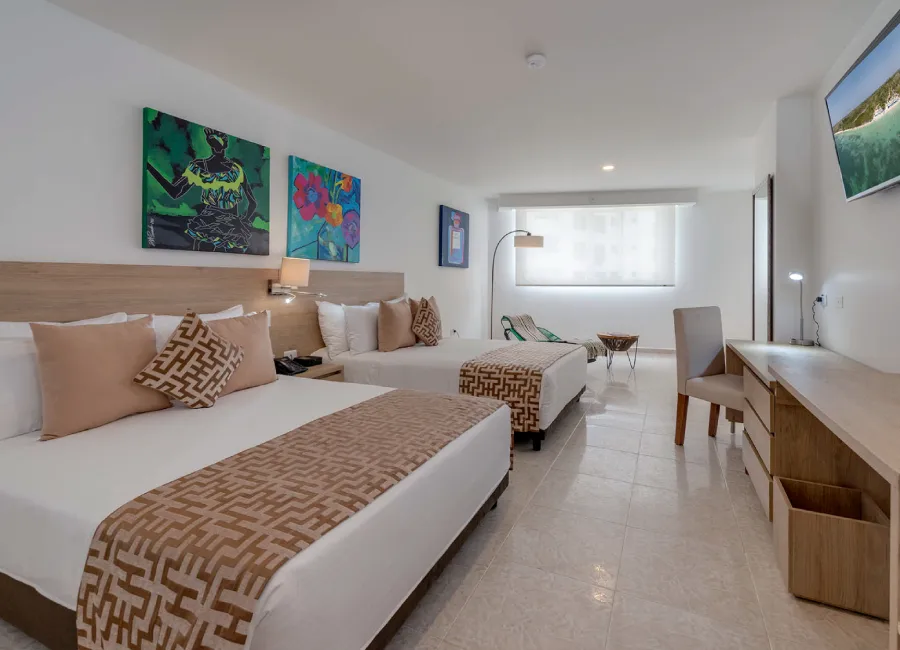 Habitación moderna con camas dobles, cuadros y sala con ventanal luminosa