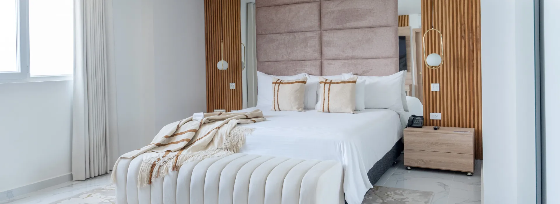 Dormitorio moderno con cama doble, cabecero tapizado y mesita de noche