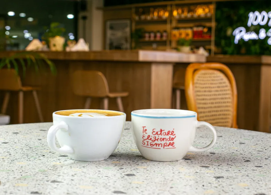 Dos tazas de café sobre mesa en terraza nocturna, con texto “Te estoy eligiendo siempre”