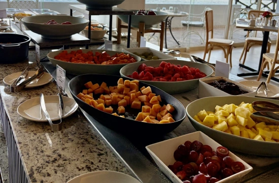 Buffet con ensaladas y verduras en recipientes: tomates, calabaza y m&aacute;s.