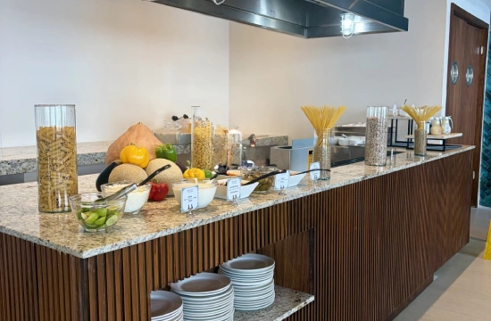 Mesa de desayuno con cereales, frutas, recipientes y utensilios en hotel