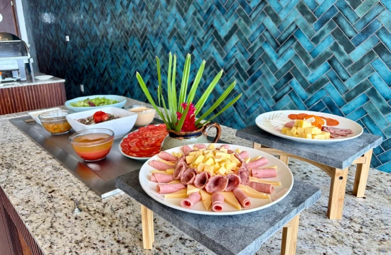 Mesa con platos de comida y bebidas sobre fondo de azulejos azules.