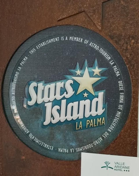 Placa redonda con el texto "Stars Island La Palma", parte del astro-turismo, junto a "Valle Aridane Hotel".