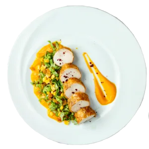 Sliced meat, vegetable mix, and sauce artfully arranged on a white plate.