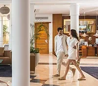 Couple walking in a bright, modern hotel lobby.