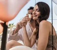 Two people enjoying champagne, surrounded by balloons.