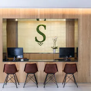 Hotel reception area with four chairs and computers.