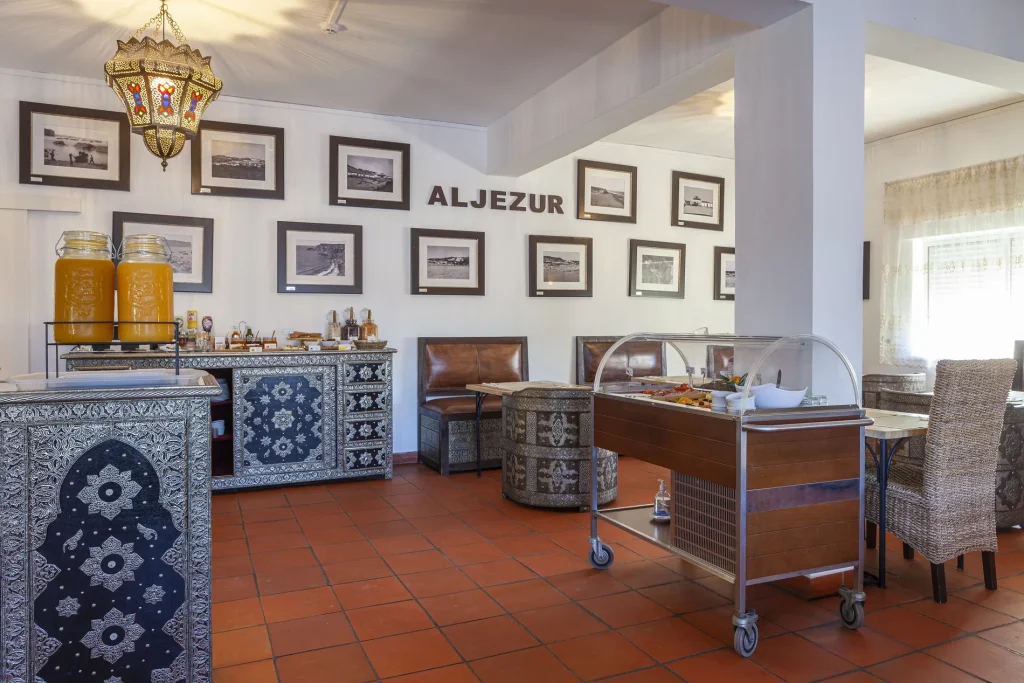 Cozy dining area with buffet setup, ornate furniture, framed photos, and bright decor.
