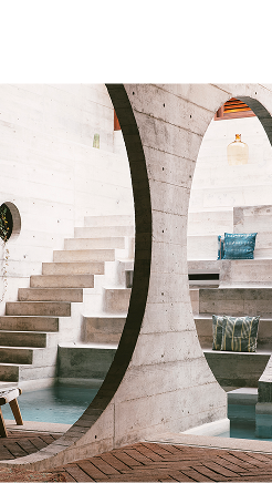 Pasillo interior con columnas de concreto y escaleras hacia arriba