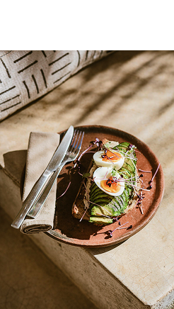 Tazón de sopa con huevo escalfado y verduras, con cubiertos al lado
