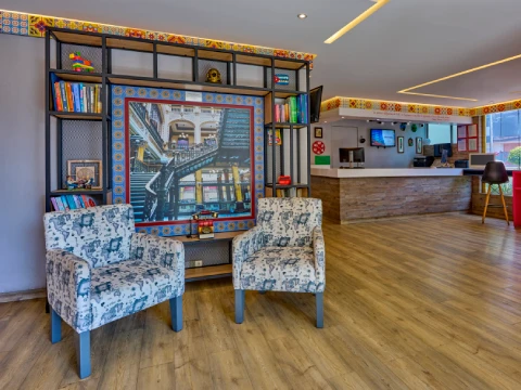 Dos sillones frente a una estanter&iacute;a y un mostrador en una sala con piso de madera.