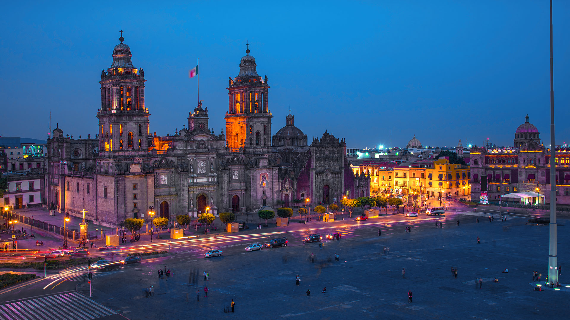 Catedral iluminada al anochecer en el Z&oacute;calo de Ciudad de M&eacute;xico, con luces y tr&aacute;fico en movimiento.