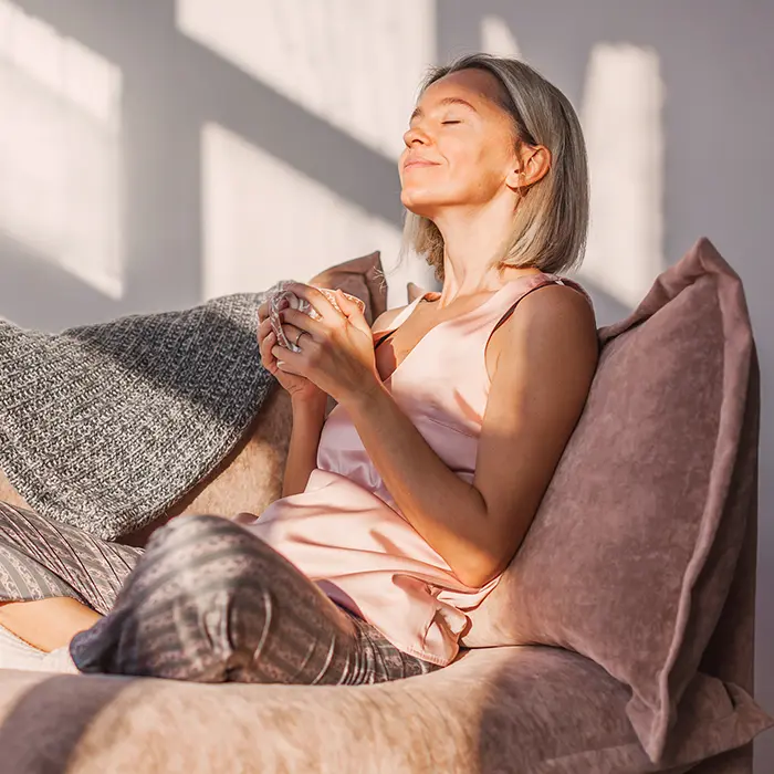 Relaxed woman with a cup of coffee in her hands