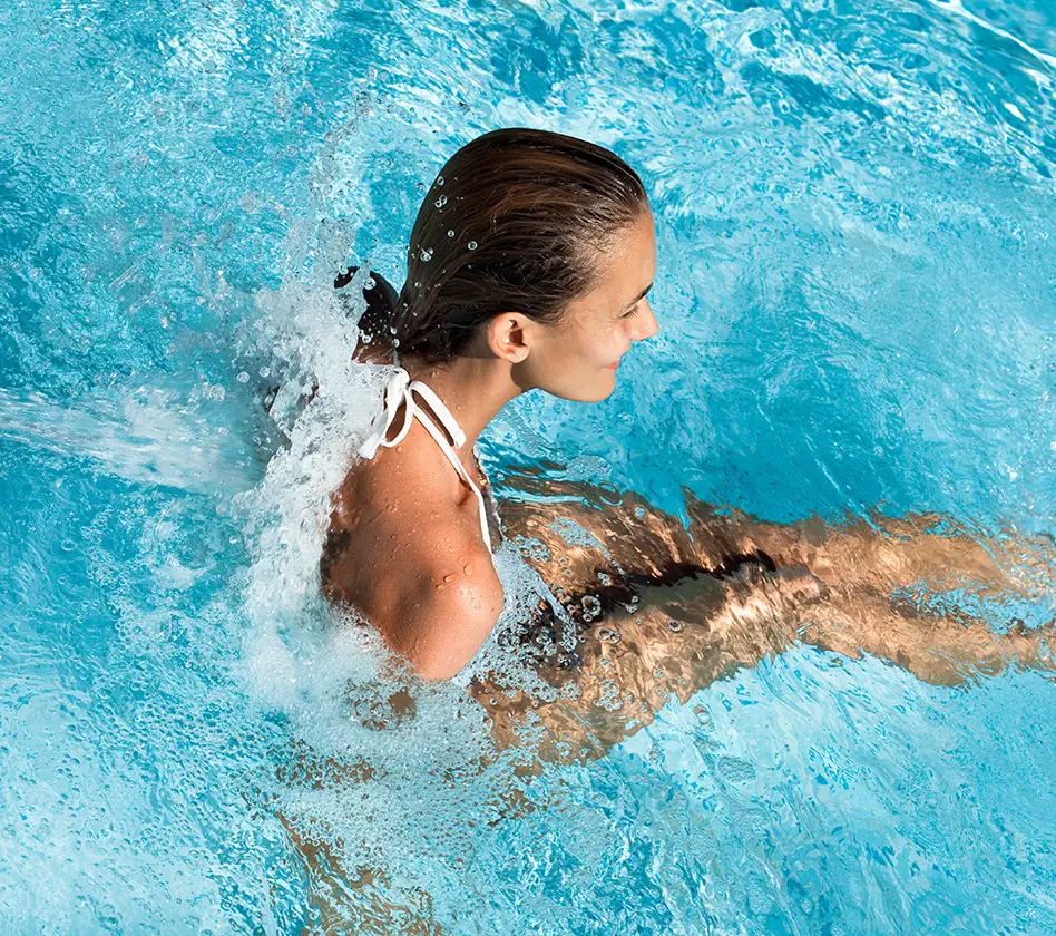Woman under the thermal water outlet