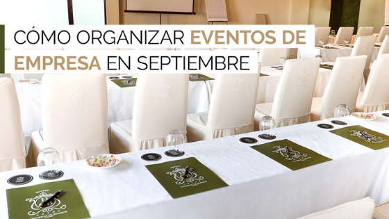 Sala de conferencias preparada para eventos empresariales, con carpetas y bolígrafos sobre cada asiento.