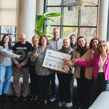 Grupo de personas sosteniendo un cartel en un lugar interior.