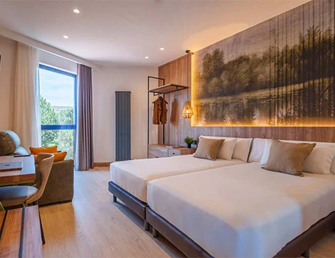 Habitación moderna con camas dobles, decoración natural y ventana grande.