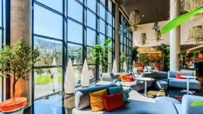 Sala moderna con sofás azules y ventanas grandes que dan al exterior.