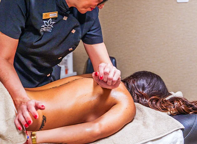 Persona recibiendo un masaje en la espalda por un profesional en un ambiente relajante.