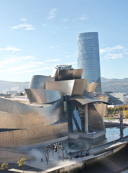 Museo Guggenheim Bilbao con estructura moderna y una escultura de araña en la entrada.