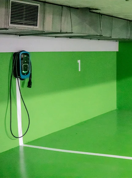 Estación de carga para vehículos eléctricos en pared verde con número 1.