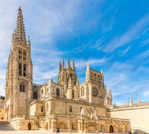 Catedral gótica con cielo azul y nubes ligeras en el fondo.
