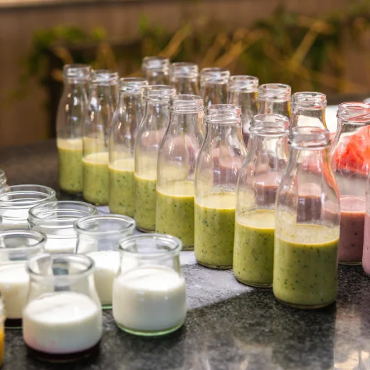 Botellas y frascos de yogur y batidos de sabores sobre una mesa.