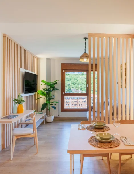 Sala moderna con comedor, planta y ventana grande al fondo.
